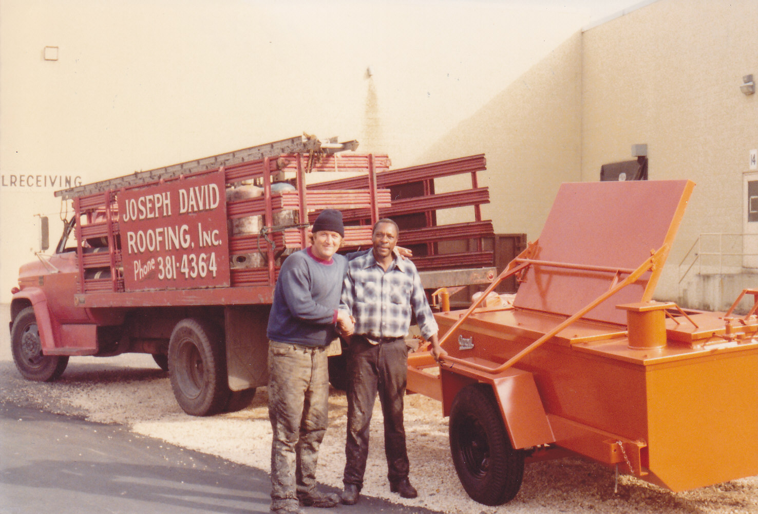 Three Joseph David Roofing crew members standing on a finished flat roof, smiling, late 1970s.