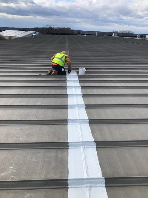 roofer repairing a metal roofing system