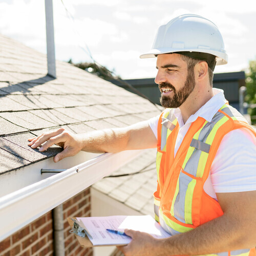 a man in a hard hat providing a roof inspection